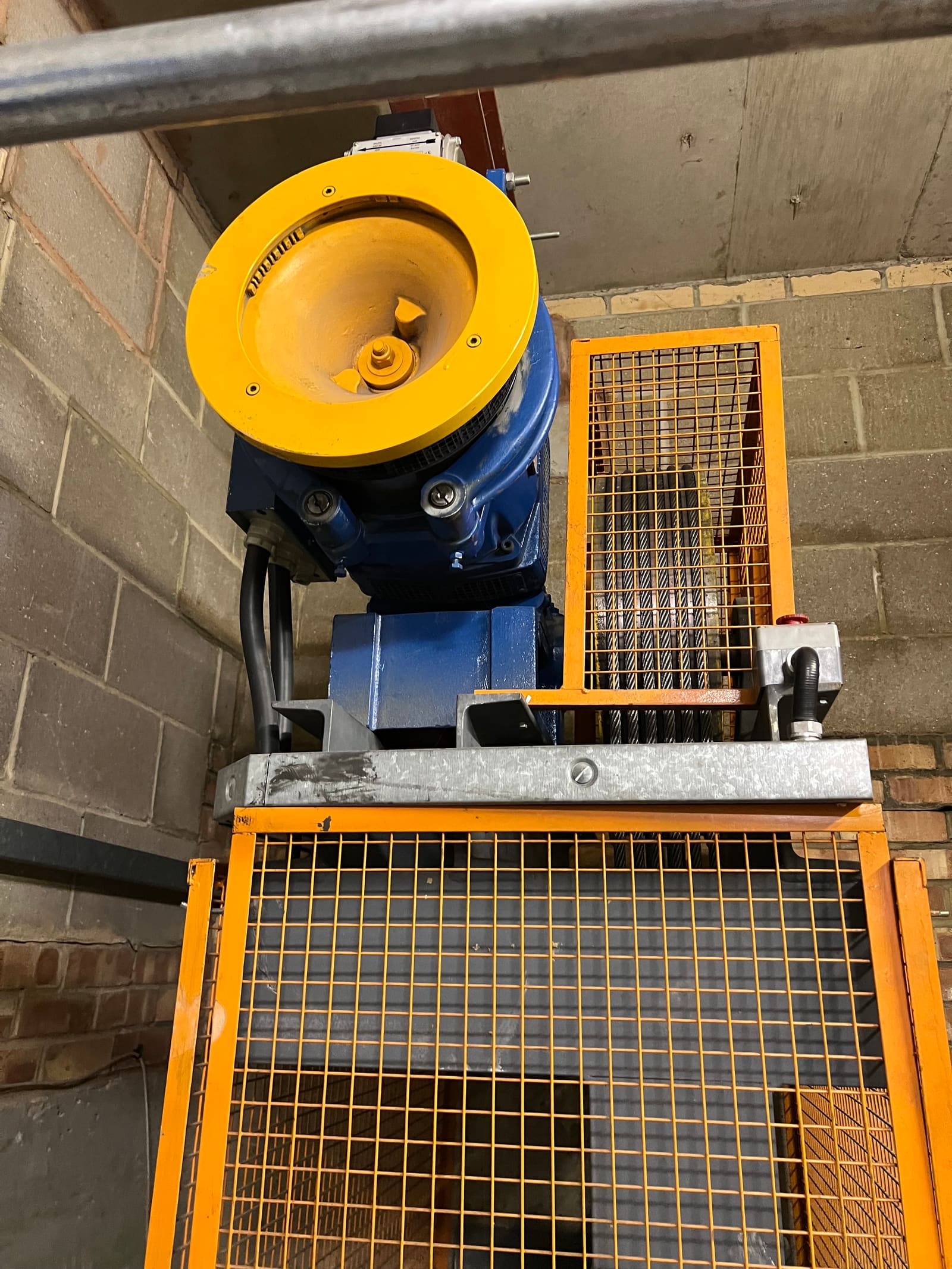 Lift traction machine with yellow sheave in a machine room