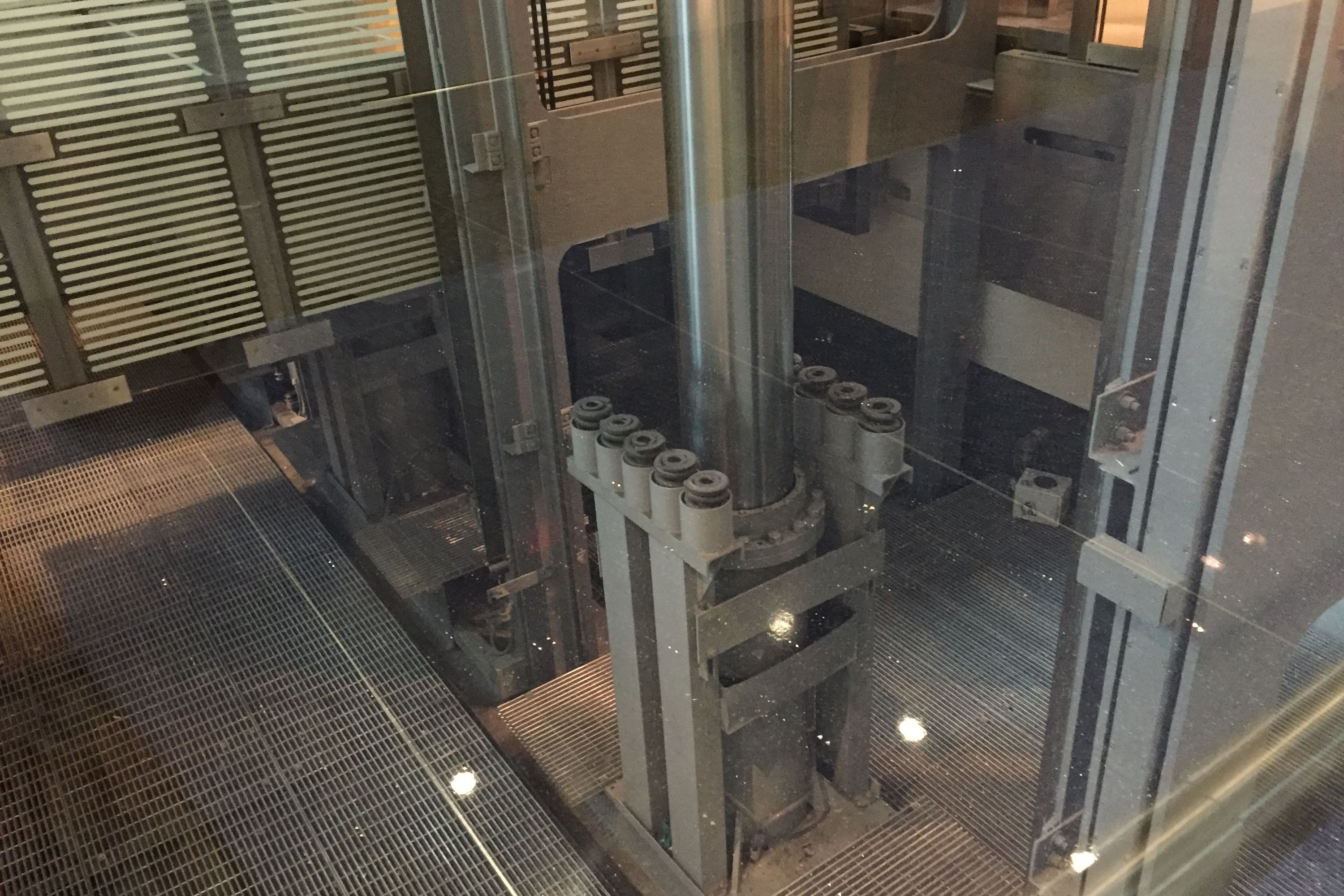 Hydraulic scenic lift pit with ram and lift equipment visible below the car