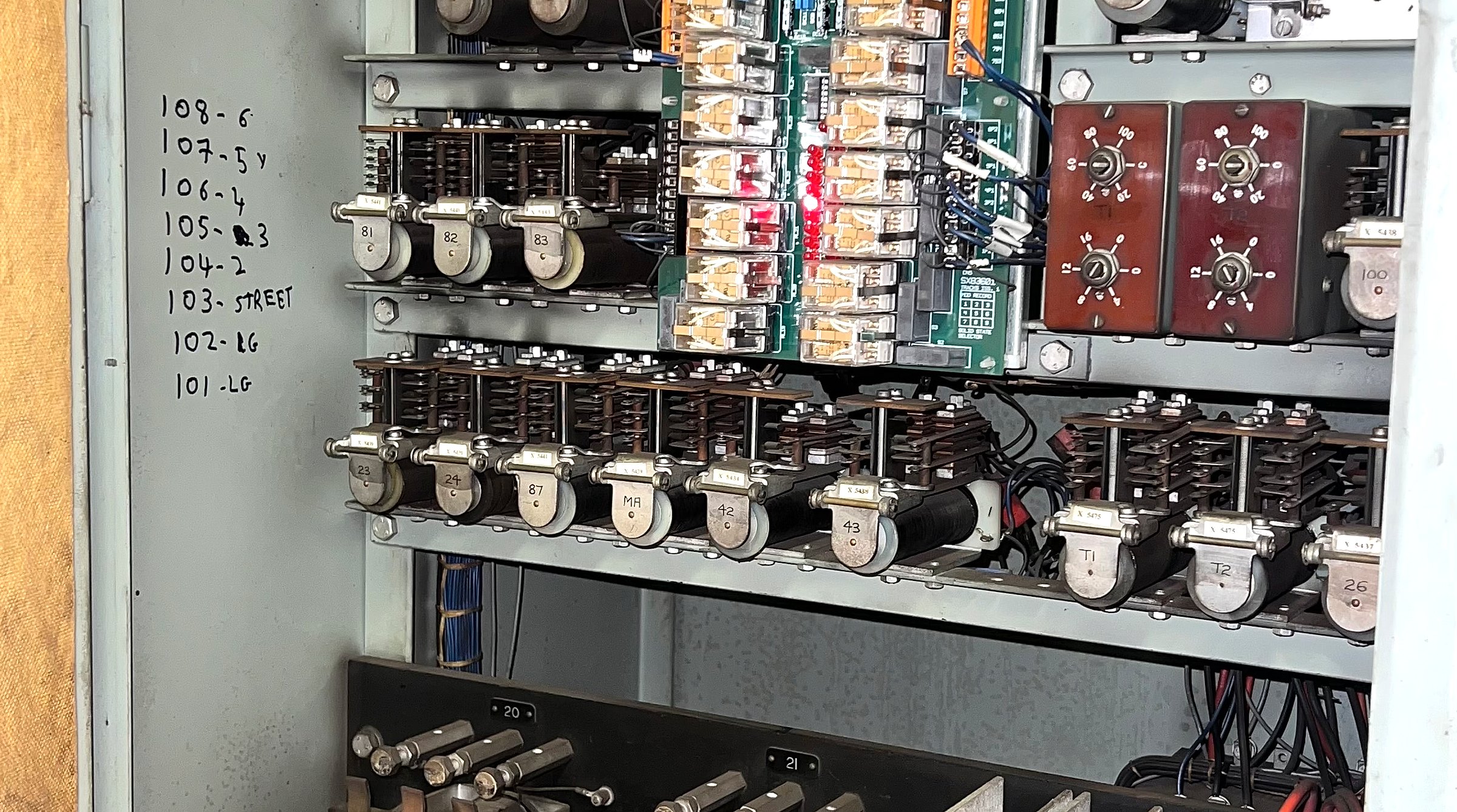 Open lift controller cabinet packed with relays, contactors and control boards
